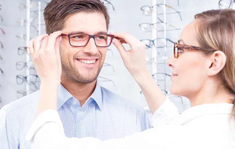 okulistka przymierzająca okulary klientowi